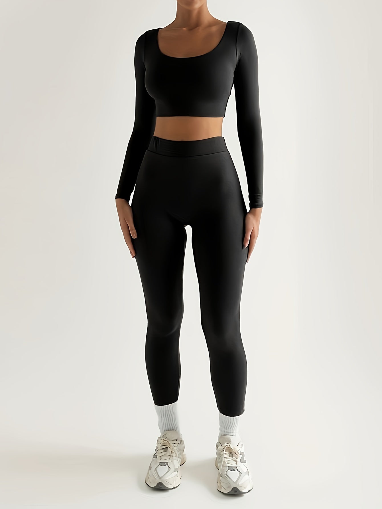 Sportset bestaande uit een crop-top met lange mouwen en een skinny broek met hoge taille