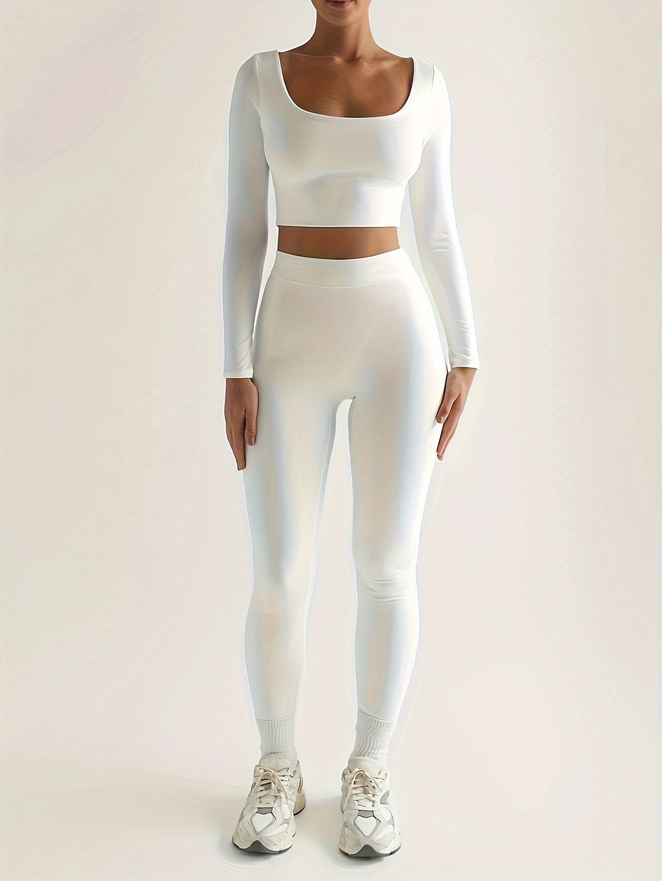Sportset bestaande uit een crop-top met lange mouwen en een skinny broek met hoge taille