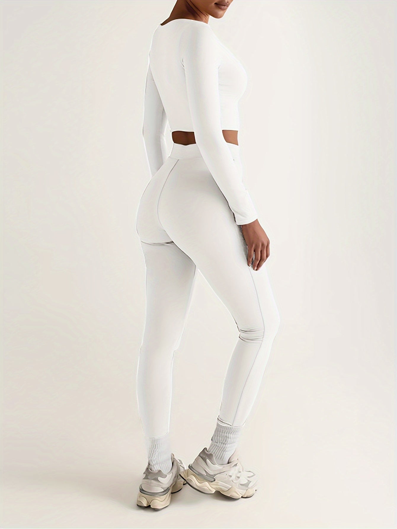 Sportset bestaande uit een crop-top met lange mouwen en een skinny broek met hoge taille