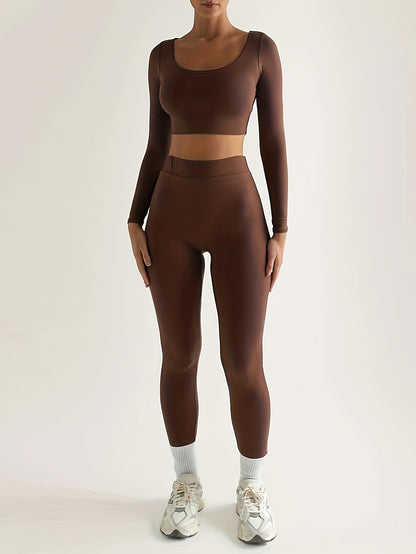 Sportset bestaande uit een crop-top met lange mouwen en een skinny broek met hoge taille